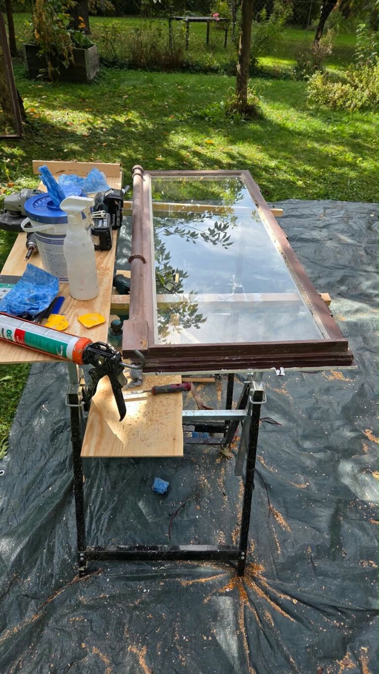Ausgebauter Holzfensterflügel auf einem Arbeitstisch während der Instandsetzung