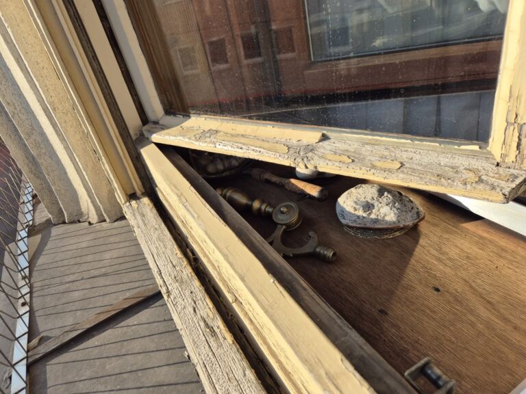 Verwitterte Holzoberflächen am geöffneten Fenster vor der Instandsetzung